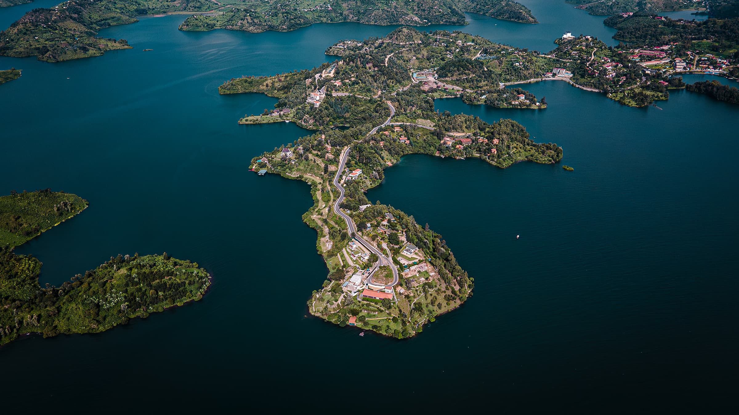 Les mille collines du Rwanda descendant vers le lac Kivu, cultures verdoyantes et forêt sous un vaste ciel
